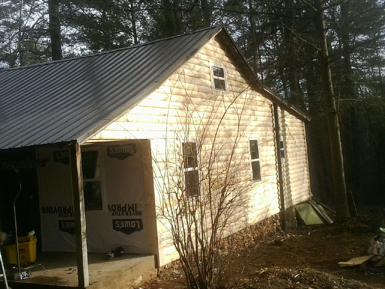 Log siding gable end under a dark metal roof edge in Marietta